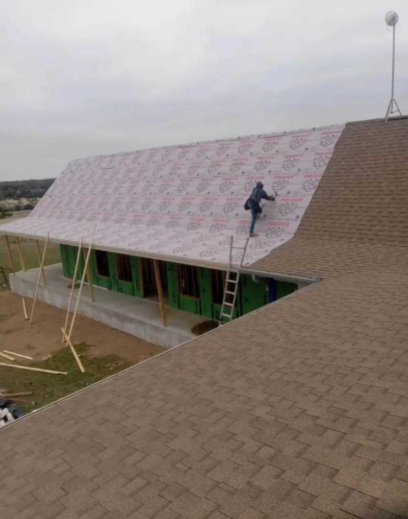 Worker preparing underlayment for a metal roof installation in Viera West